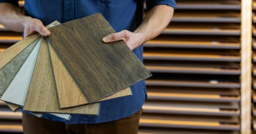 man in blue holding flooring samples